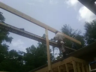 Carpenter setting a ridge beam over a new addition frame — Ice Dam Removal by Roofing Brothers in Forest Falls
