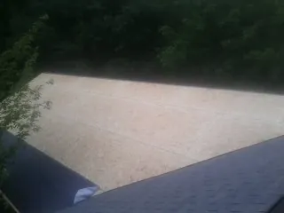 New OSB roof sheathing installed beside an existing shingle roof in Forest Falls