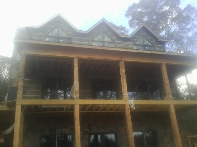 Dormers and porch framing on a large log home under construction — Roof Coating work by our crew in Forest Falls